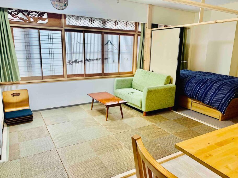 um quarto com uma cama, uma cadeira e uma mesa em MoRi House IN 伊勢佐木町 em Yokohama