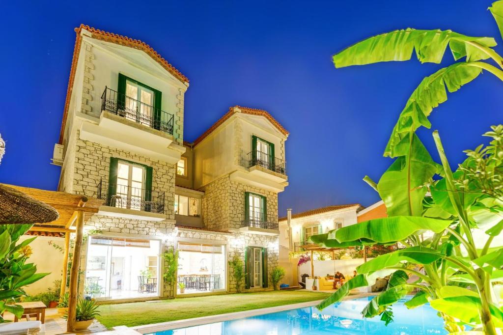 a house with a swimming pool in front of it at Melekaki Alaçatı in Cesme