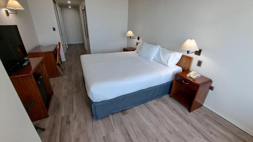 a small bedroom with a bed and a television at Hotel Diego De Almagro Costanera - Antofagasta in Antofagasta