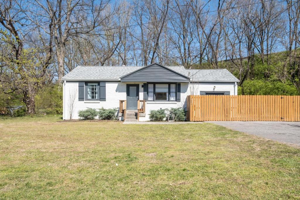 une maison blanche avec une clôture dans une cour dans l'établissement The Titan - Pet-friendly Bungalow, à Nashville