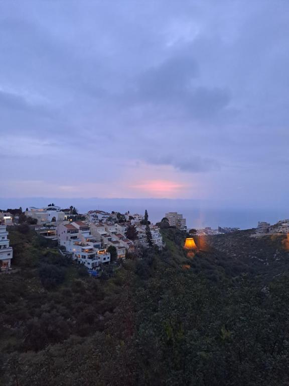 un groupe de bâtiments sur une colline au coucher du soleil dans l'établissement Sea view Carmel Mountain University, à Haïfa