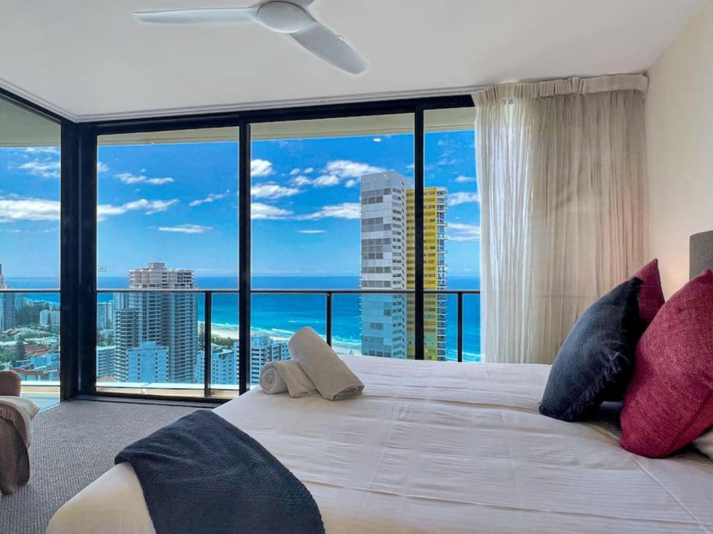 a bedroom with a large bed with a large window at 29th floor Oracle Tower 2 stunning ocean and city views in Gold Coast