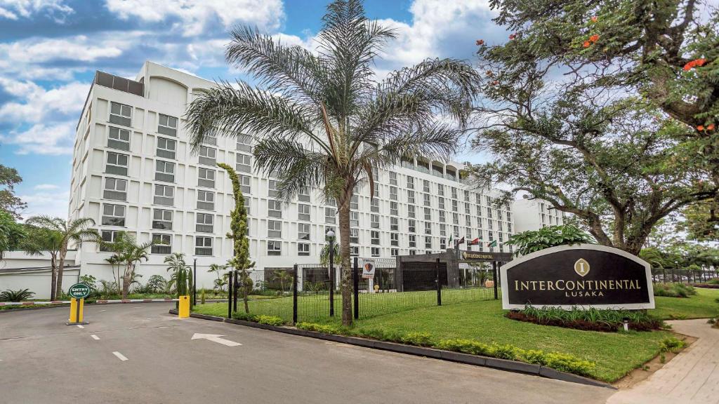 um grande edifício branco com uma placa em frente em InterContinental Lusaka, an IHG Hotel em Lusaka