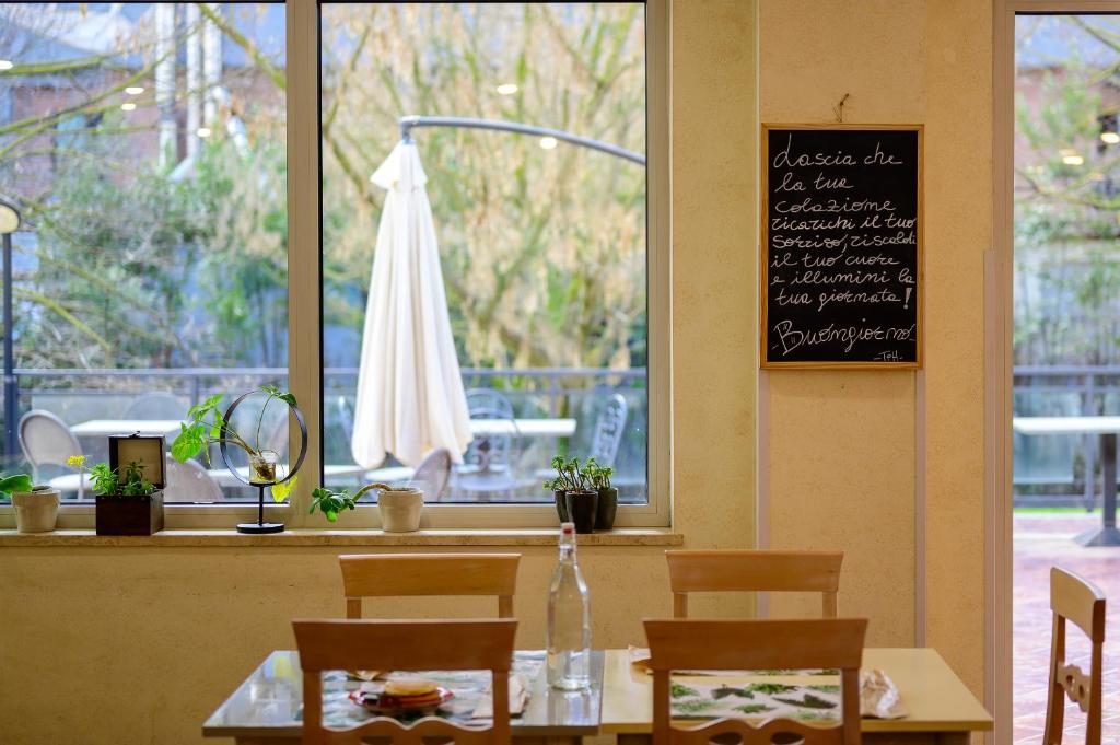 una mesa y sillas en un restaurante con pizarra en Hotel Torre Di Pratolungo, en Casal Monastero