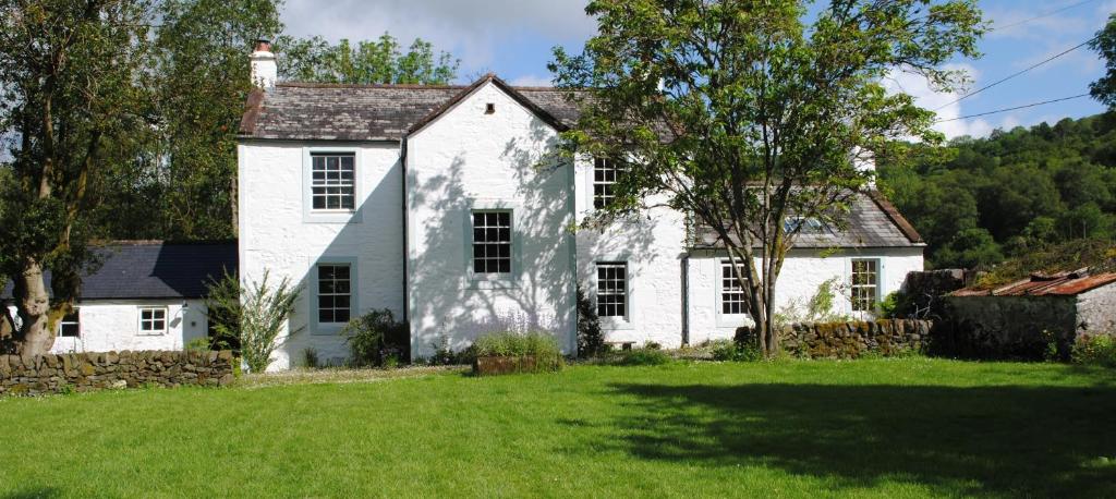 una vieja casa blanca con un patio verde en Riverside, en Thornhill