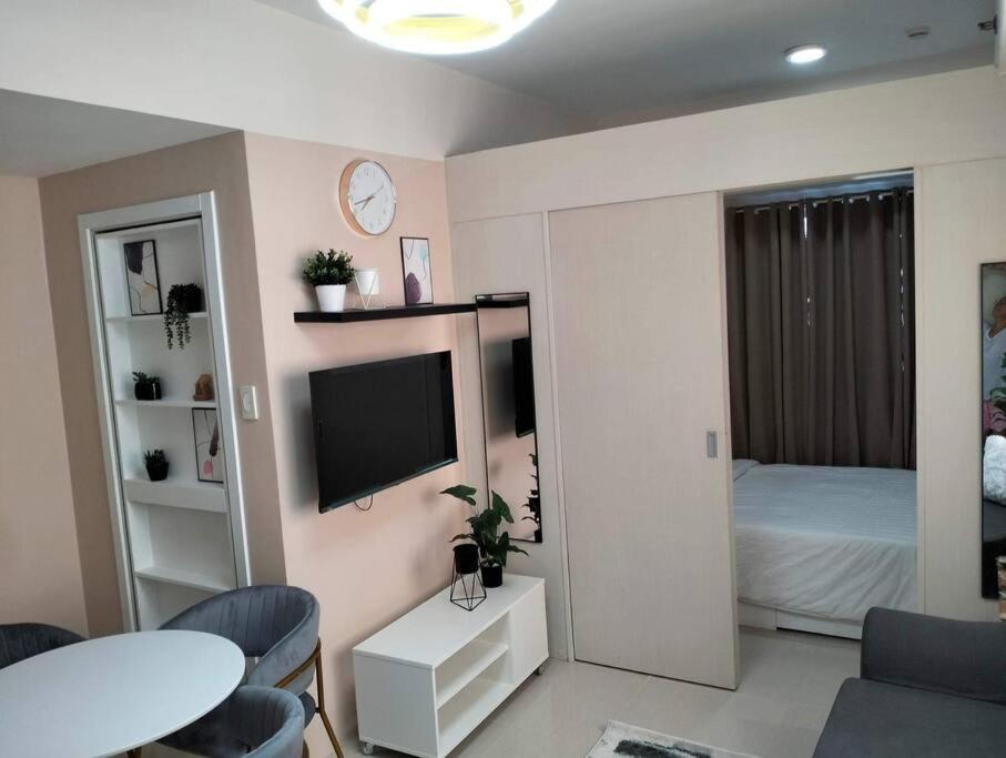 a living room with a tv and a bedroom at Cozy Flexi 1BR or 2BR condo at Southmall Las Pinas in Manila