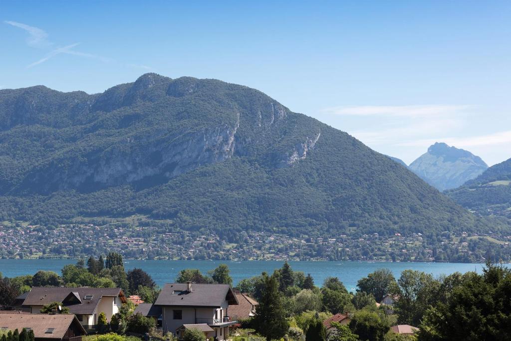 a view of a mountain with houses and a lake at La villa panoramique in Sévrier