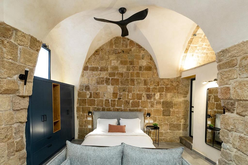 um quarto com uma cama numa parede de pedra em Mirsa em Acre