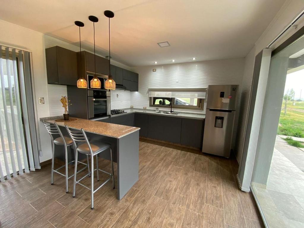 a kitchen with a counter and a refrigerator at Chalet Premium en Villa Privada "Casa Bonita" in San Rafael