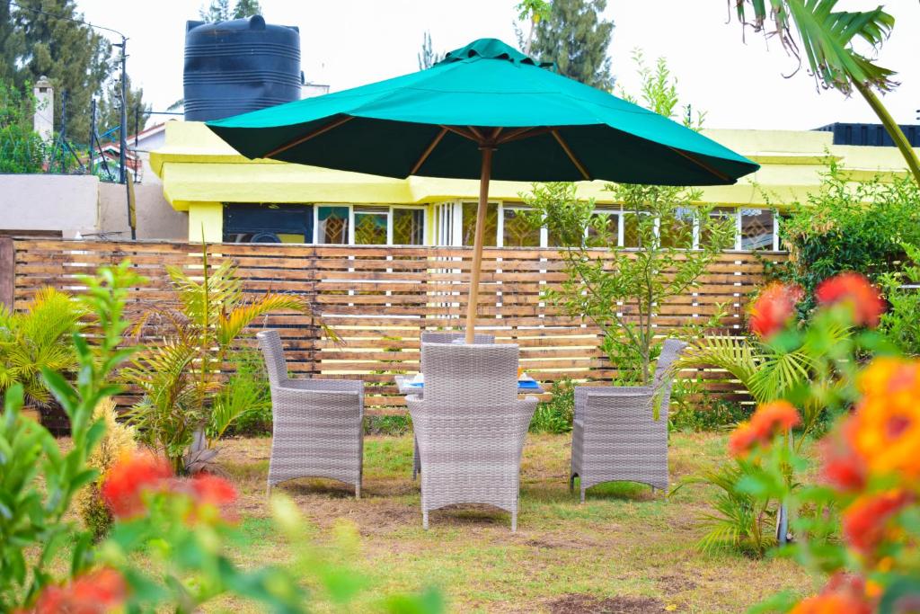 - une table et des chaises sous un parasol dans la cour dans l'établissement Havan Furnished Apartments-Greensteads, à Lake View Estate