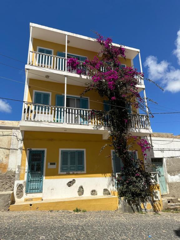 um edifício amarelo com flores ao lado em B&B Mi Ma Bo, Sal Rei, Boa Vista, Cape Verde, FREE WI-FI em Sal Rei