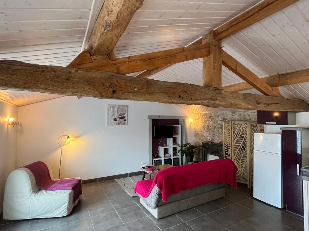 uma sala de estar com tectos em madeira e uma mesa e cadeiras em Domaine de la moriniere em Commequiers