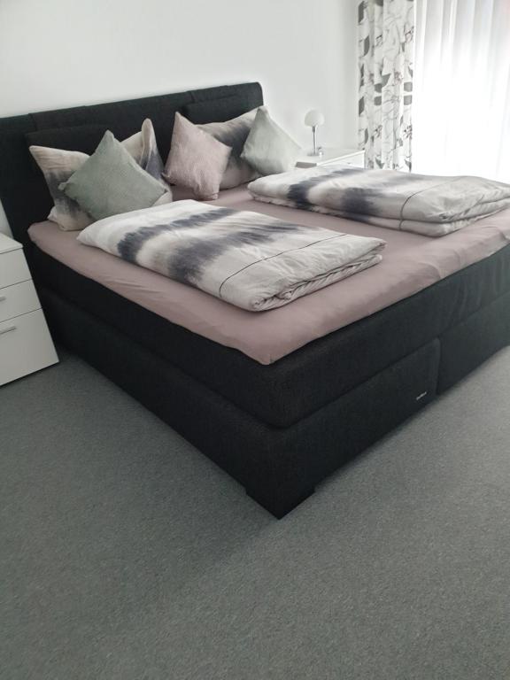 łóżko z 2 poduszkami w pokoju w obiekcie Maje Am alten Binnenhafen w mieście Emden