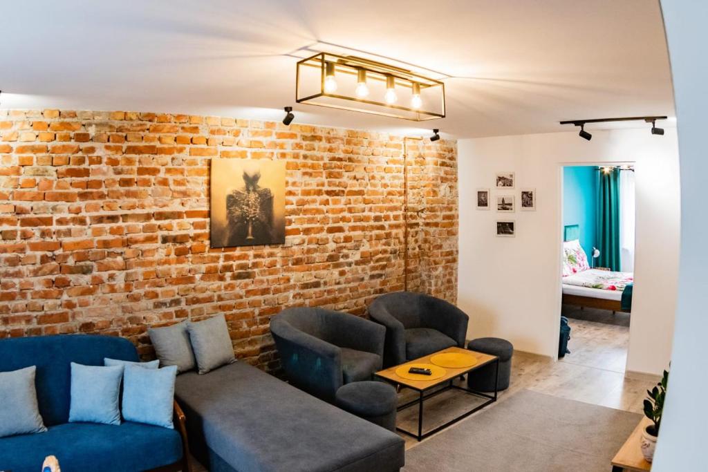 een woonkamer met een bakstenen muur bij Loft Apartament ULA in Elblag