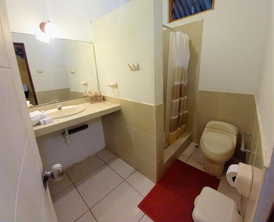 a bathroom with a toilet and a sink and a mirror at Mancora y Sol in Máncora