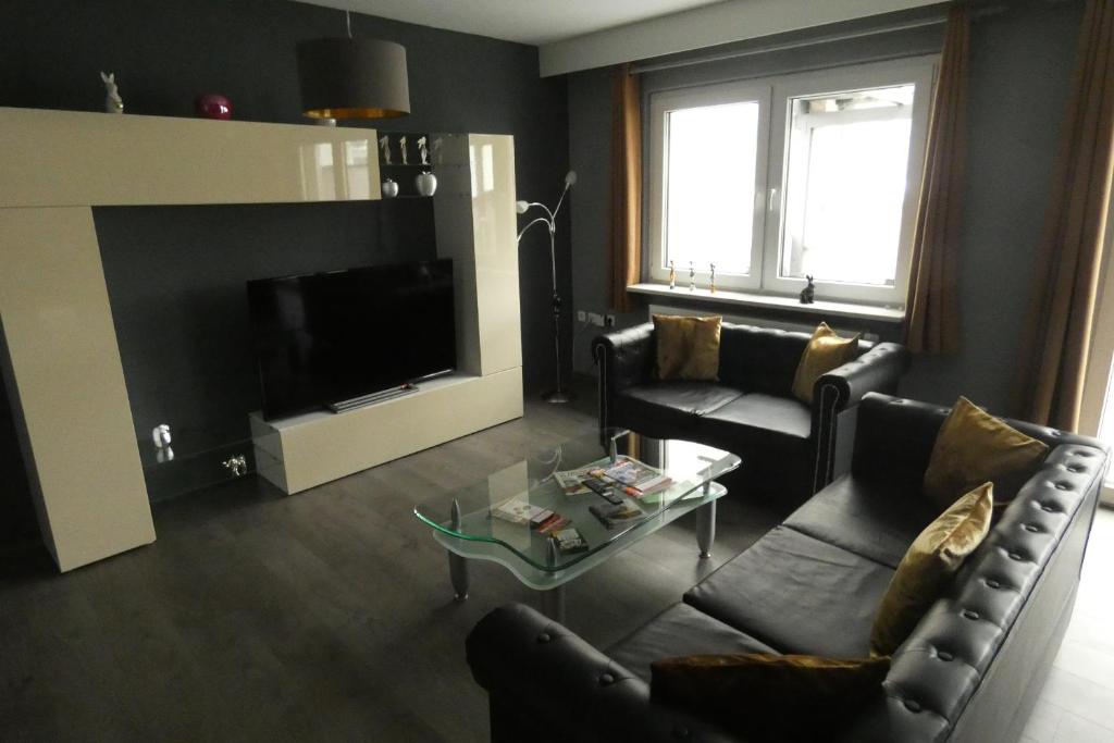 Sala de estar con 2 sofás y TV en Dachterrasse, en Schwandorf