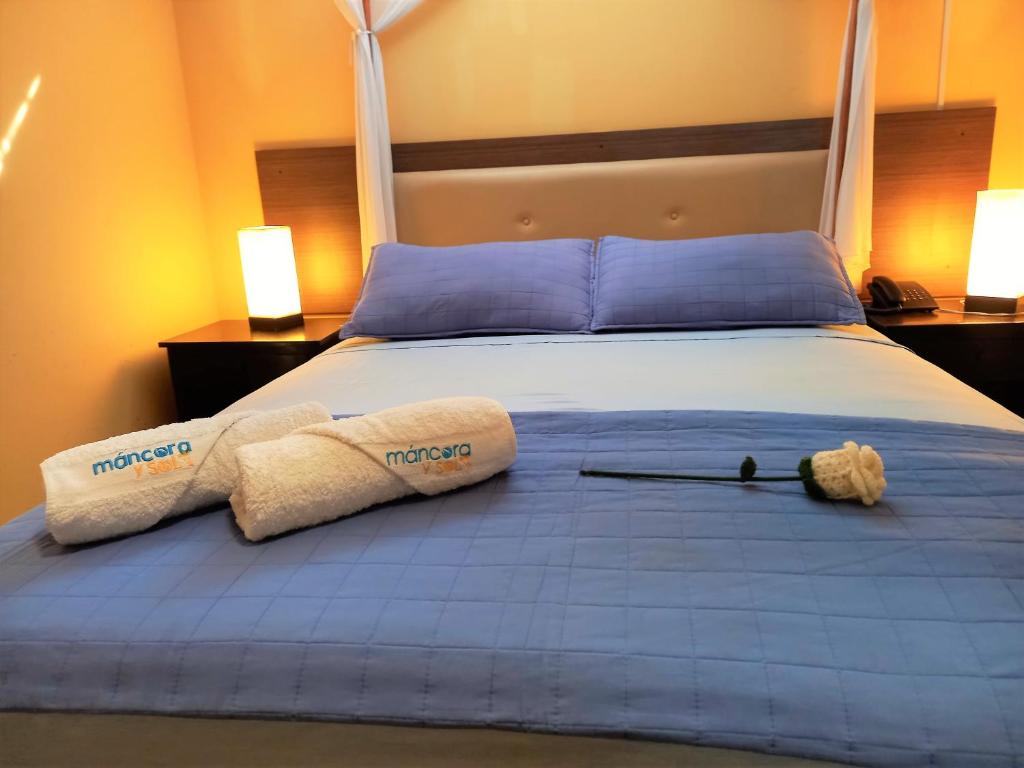a bedroom with a bed with two towels on it at Mancora y Sol in Máncora