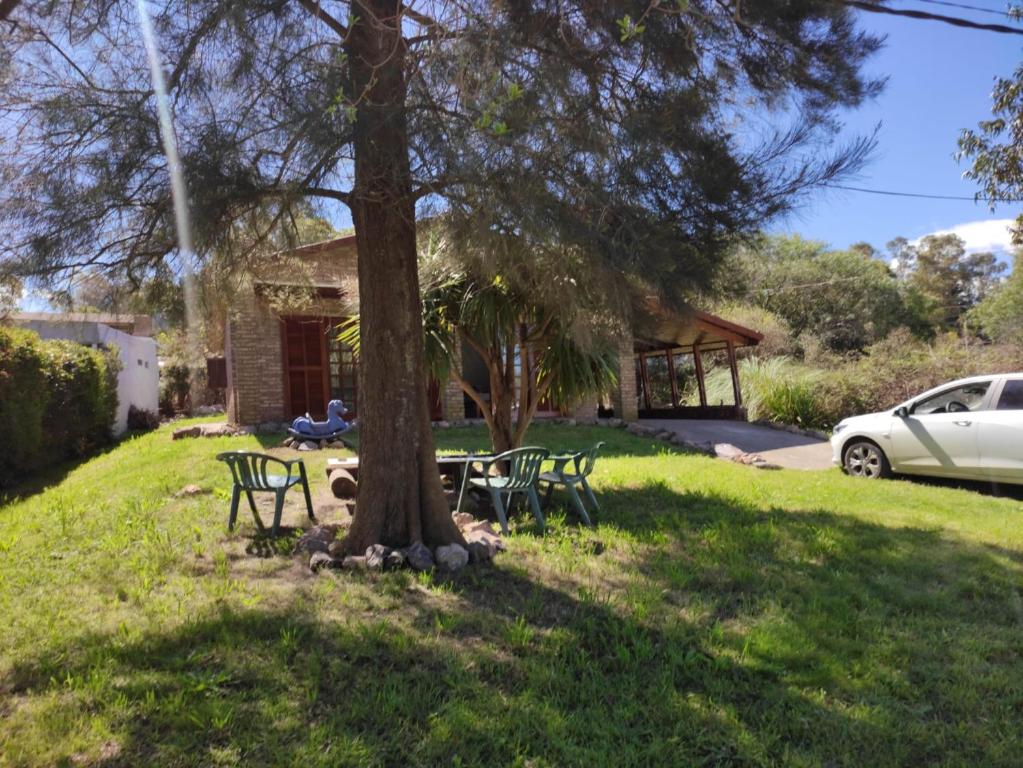 una mesa y sillas bajo un árbol en un patio en Casa playa hermosa 3 dormitorios en Playa Hermosa