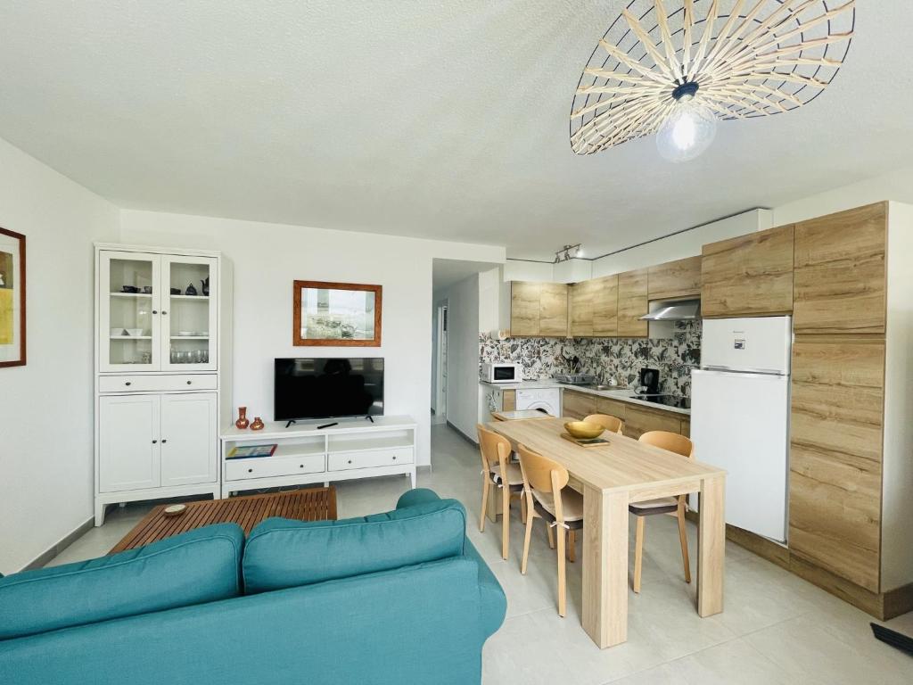 una cucina e una sala da pranzo con un divano blu e un tavolo di A552 - Cardenal 4 - 2004 Finestrat s.l. a Cala de Finestrat