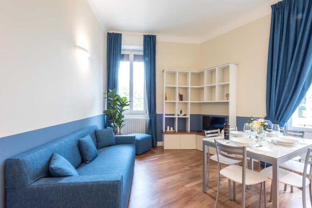 een woonkamer met een blauwe bank en een tafel bij Spazio Stoppani - BIG in Milaan