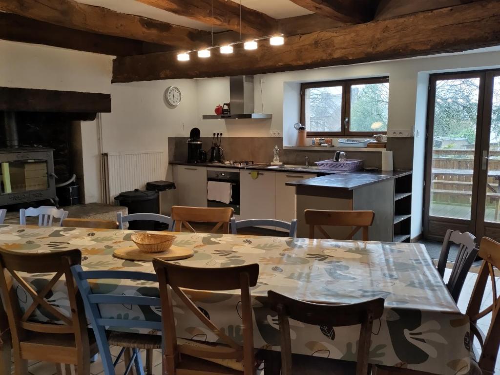 a kitchen with a table and chairs in a room at Maison familiale, 15couchages, de charme au cœur de la Bretagne - 20 min de Vannes in Lizio