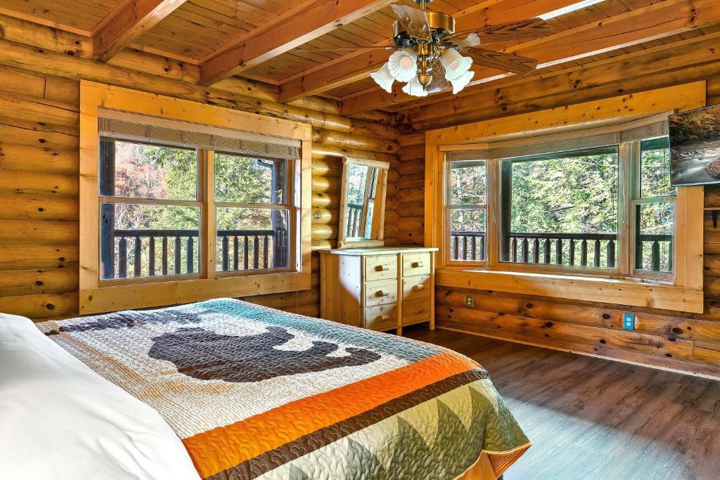 赛维尔维尔Luxury Heated Pool Cabin with Mountain Views, Theater & Game room的小木屋内一间卧室配有床和窗户