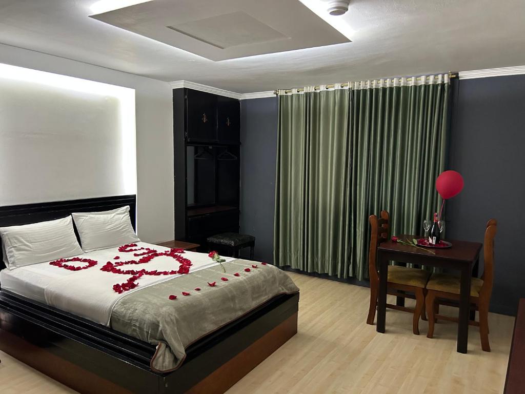um quarto com uma cama, uma mesa e uma secretária em IÑAQUITO GOLD em Quito