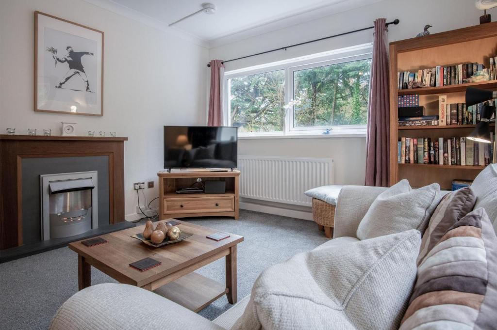 a living room with a couch and a tv at Glenvale - 2 Bedroom Apartment - Saundersfoot in Saundersfoot