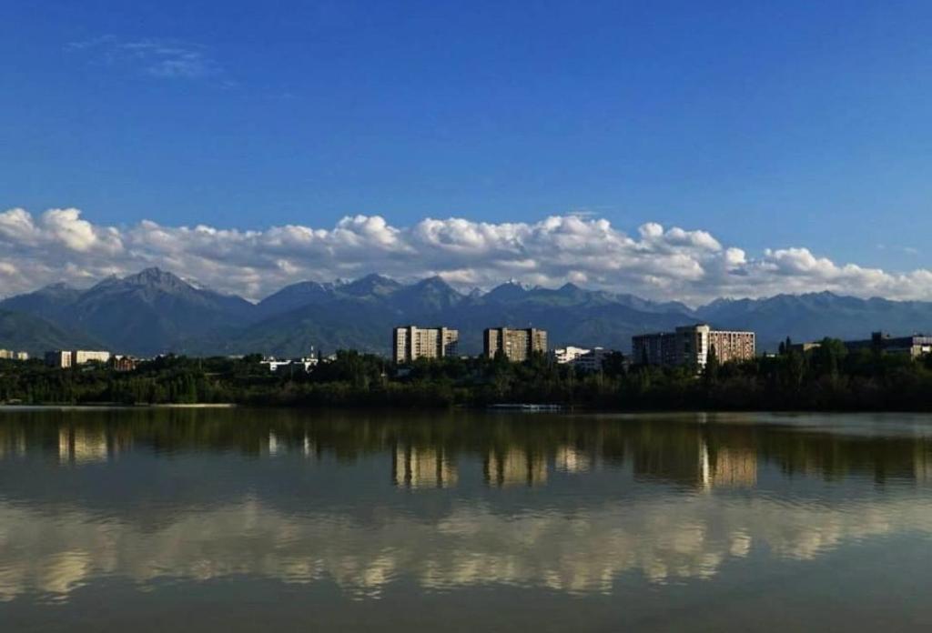 a large body of water with a city and mountains at Tastaq hostel in Almaty