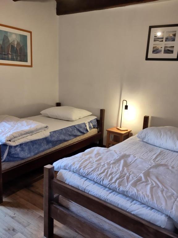 a bedroom with two beds and a lamp in it at Maison familiale, 15couchages, de charme au cœur de la Bretagne - 20 min de Vannes in Lizio