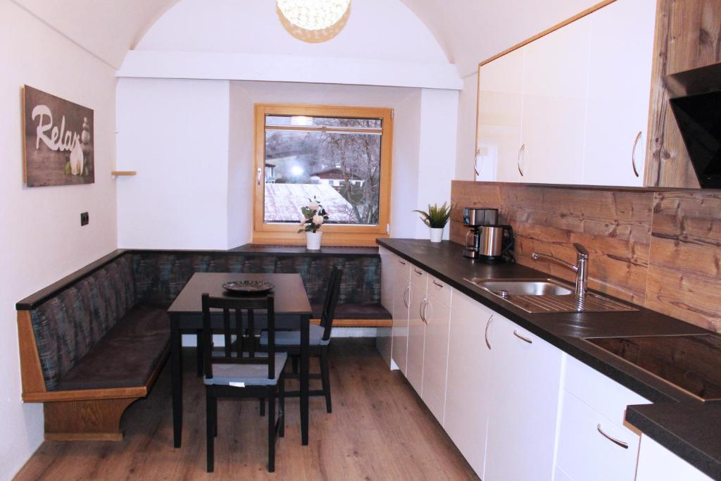 - une cuisine avec une table, des chaises et un évier dans l'établissement Apartment GipfelSturm Tirol, à Ried im Oberinntal