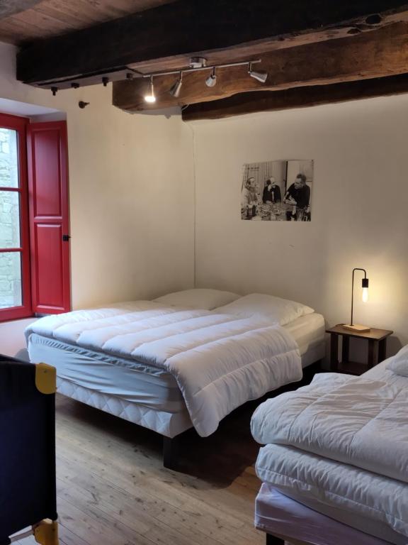 a bedroom with two beds and a red window at Maison familiale, 15couchages, de charme au cœur de la Bretagne - 20 min de Vannes in Lizio