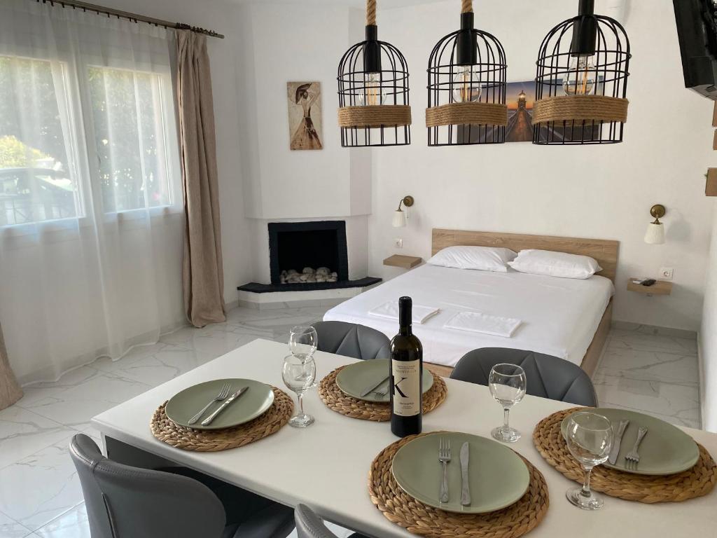 Habitación con cama y mesa con copas de vino en sofia guesthouse en Nea Skioni