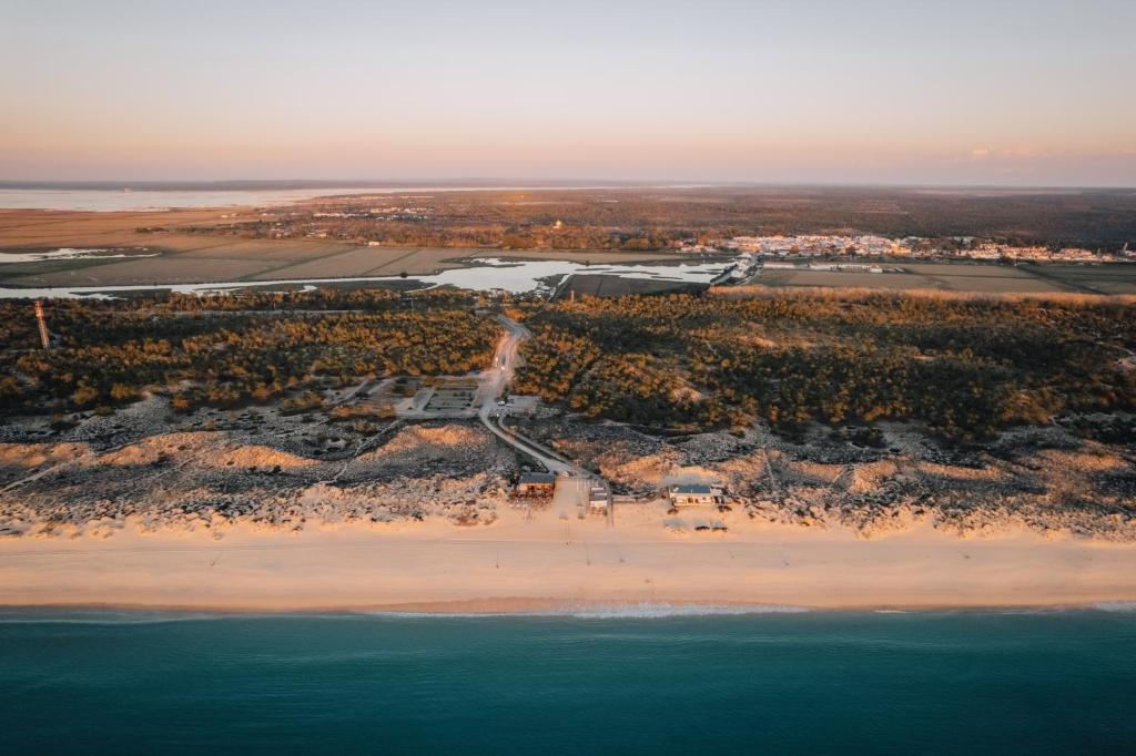 an aerial view of a beach and the ocean at AlmaLusa Comporta in Comporta