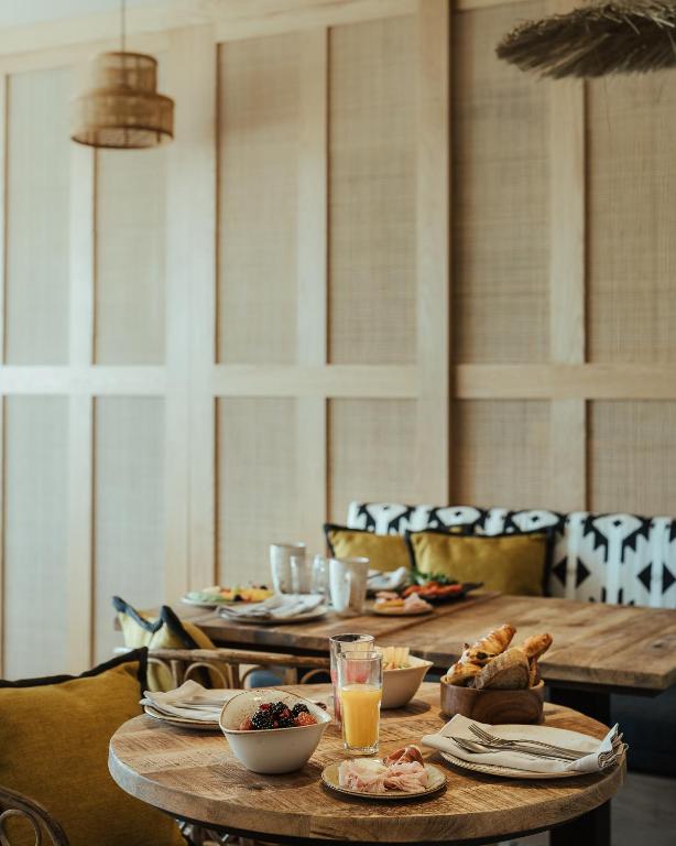 a table with plates of food and drinks on it at AlmaLusa Comporta in Comporta