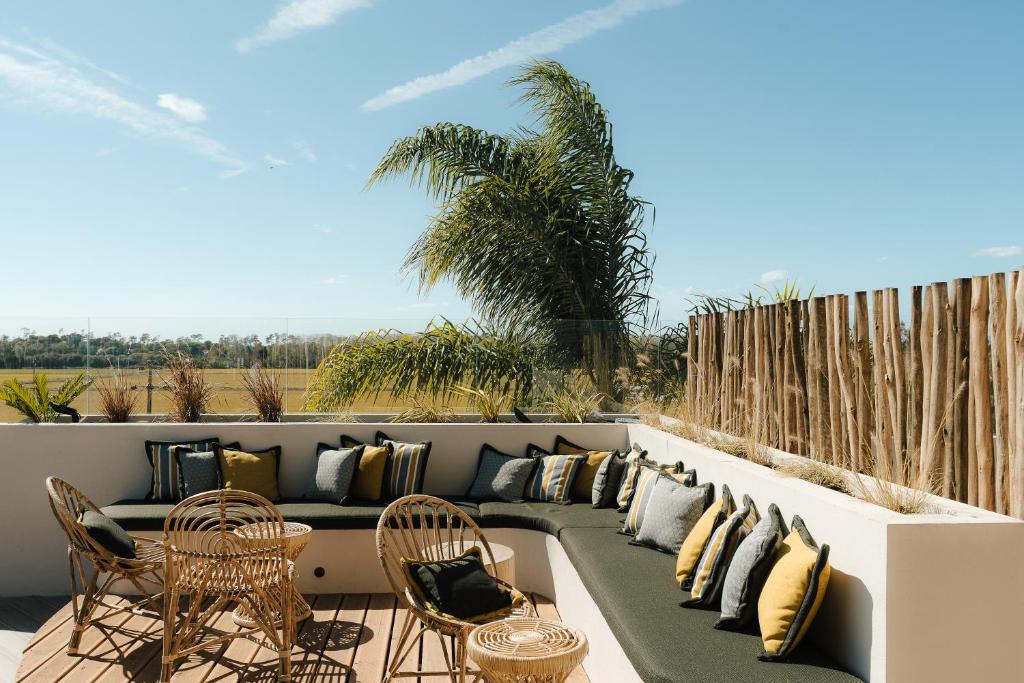a patio with a couch and tables and chairs at AlmaLusa Comporta in Comporta