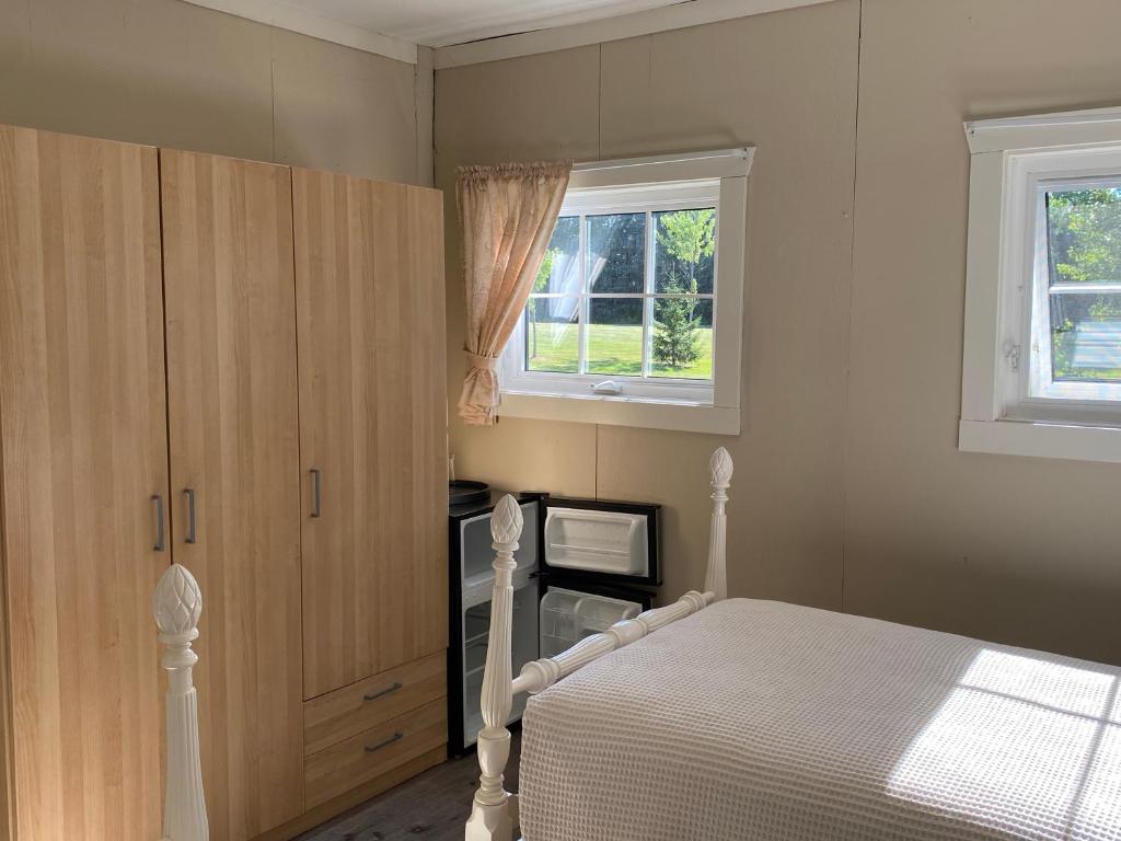 a bedroom with a white bed and a window at The Barn at Spry Point in Little Pond