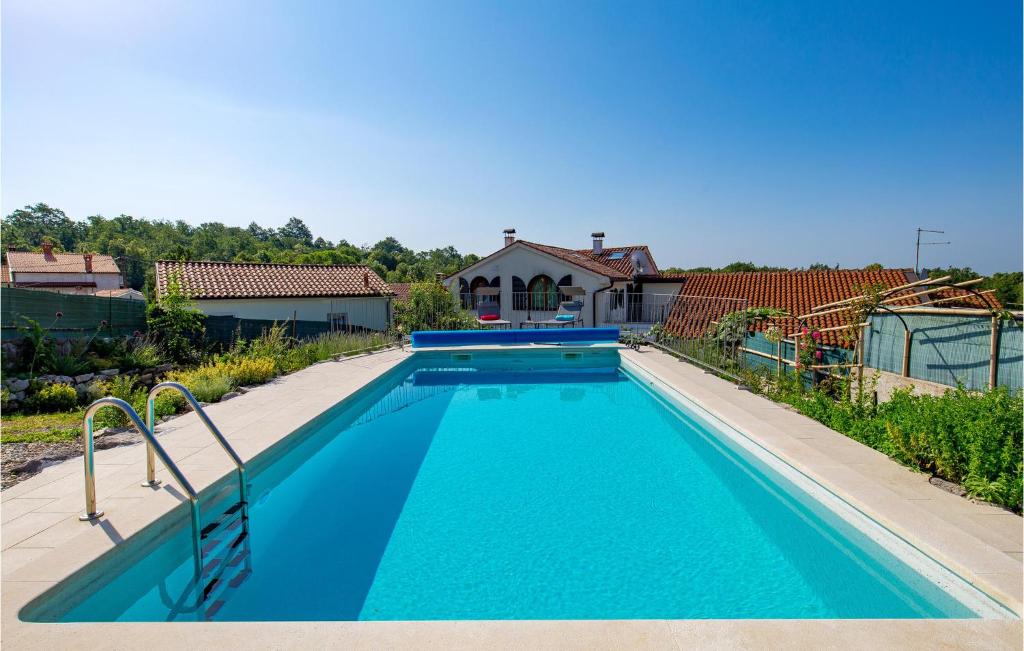 una piscina de agua azul frente a una casa en Nice Home In Ruzici With 3 Bedrooms, Wifi And Outdoor Swimming Pool, en Ružići