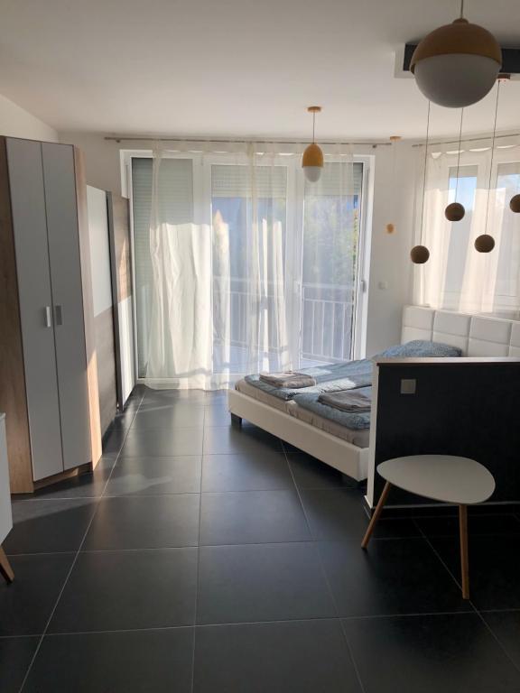 um quarto com uma cama, uma mesa e uma janela em Kiad-Lak Apartman em Szeged