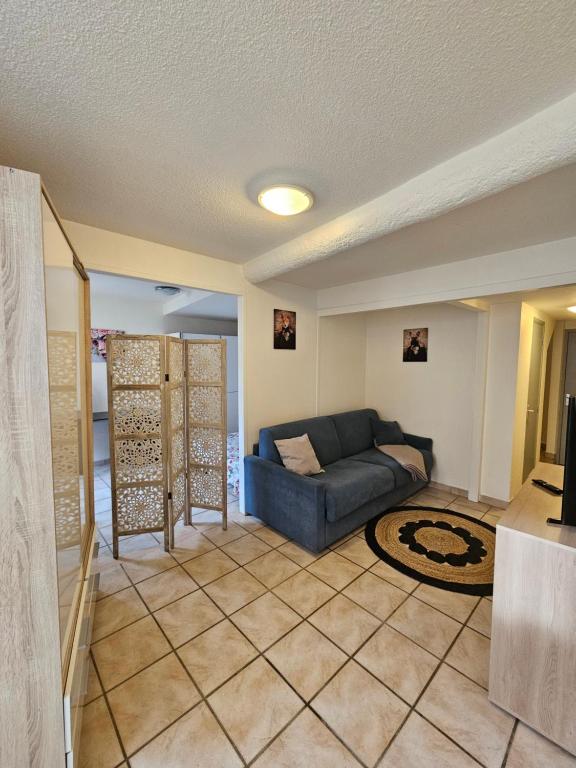 ein Wohnzimmer mit einem blauen Sofa und einem Teppich in der Unterkunft Charmant 2 pièces centre Sospel in Sospel