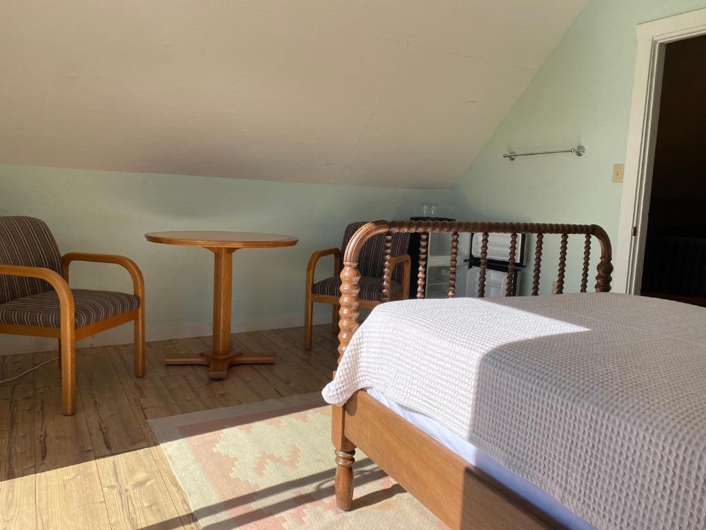 a bedroom with a bed and a table and chairs at The Barn at Spry Point in Little Pond