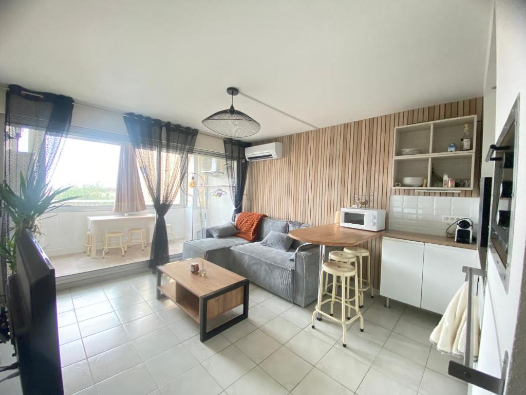 una cucina e un soggiorno con divano e tavolo di Etoile de thau a Frontignan