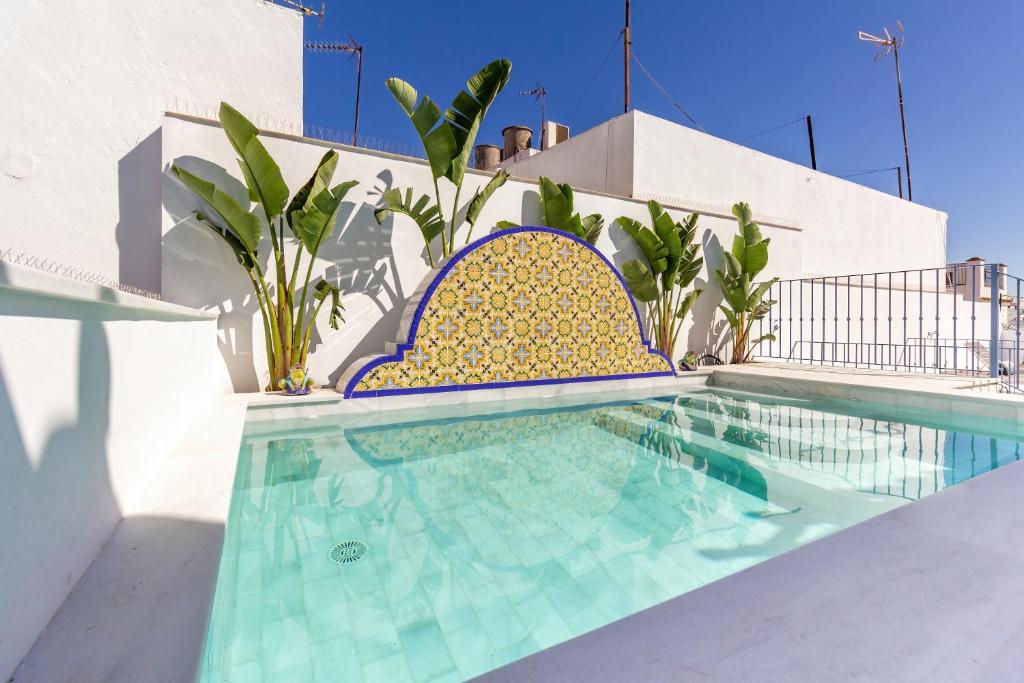 een zwembad met blauwe en gele tegels op een huis bij Feelathome San Lorenzo Apartments in Sevilla