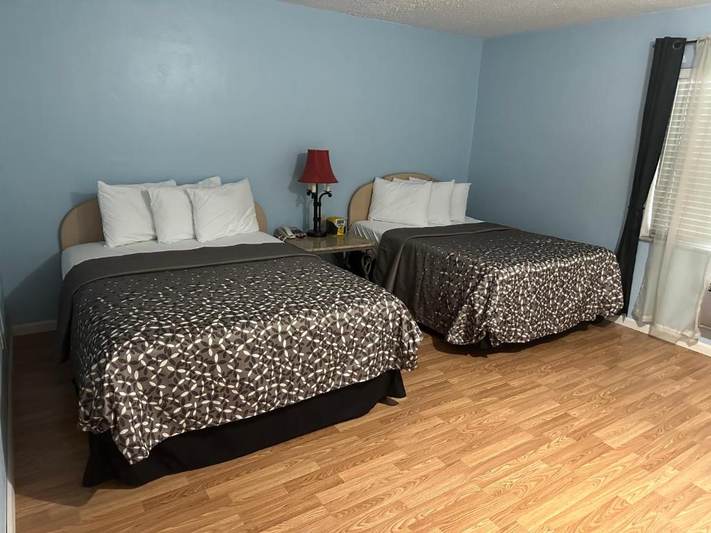クリアウォーターにあるTHE FLORIDIAN INNの青い壁とウッドフロアの客室で、ベッド2台が備わります。