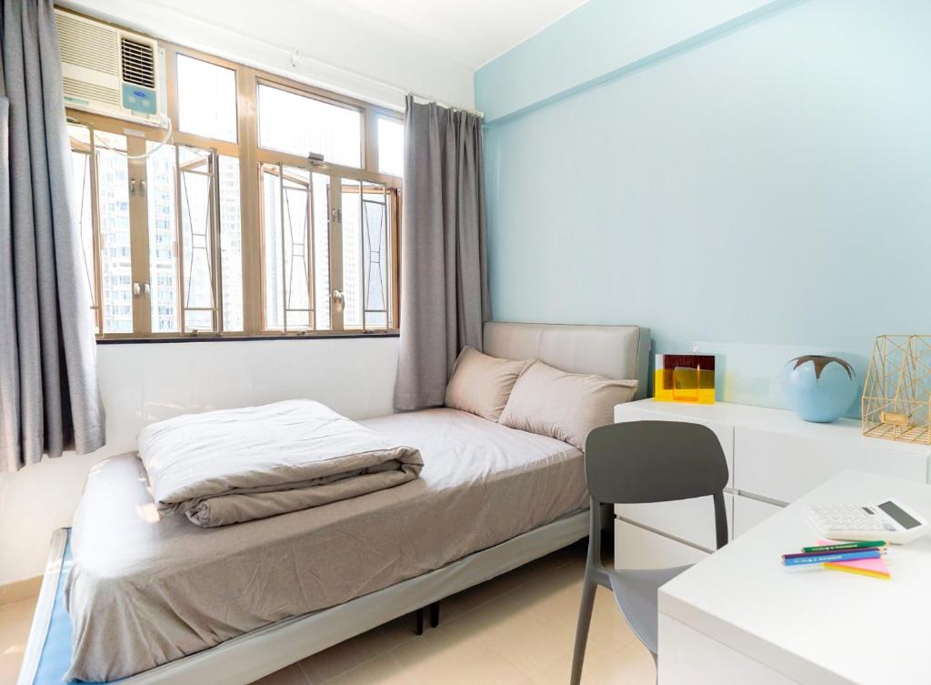 a small bedroom with a bed and a desk at CoLiving Space - Hennessy Road 113 Wan Chai MTR in Hong Kong