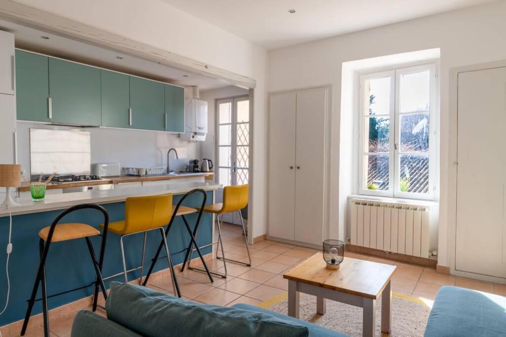 uma cozinha com armários verdes e cadeiras amarelas numa sala de estar em BEL APPARTEMENT DANS LE CENTRE D'AVIGNON em Avignon