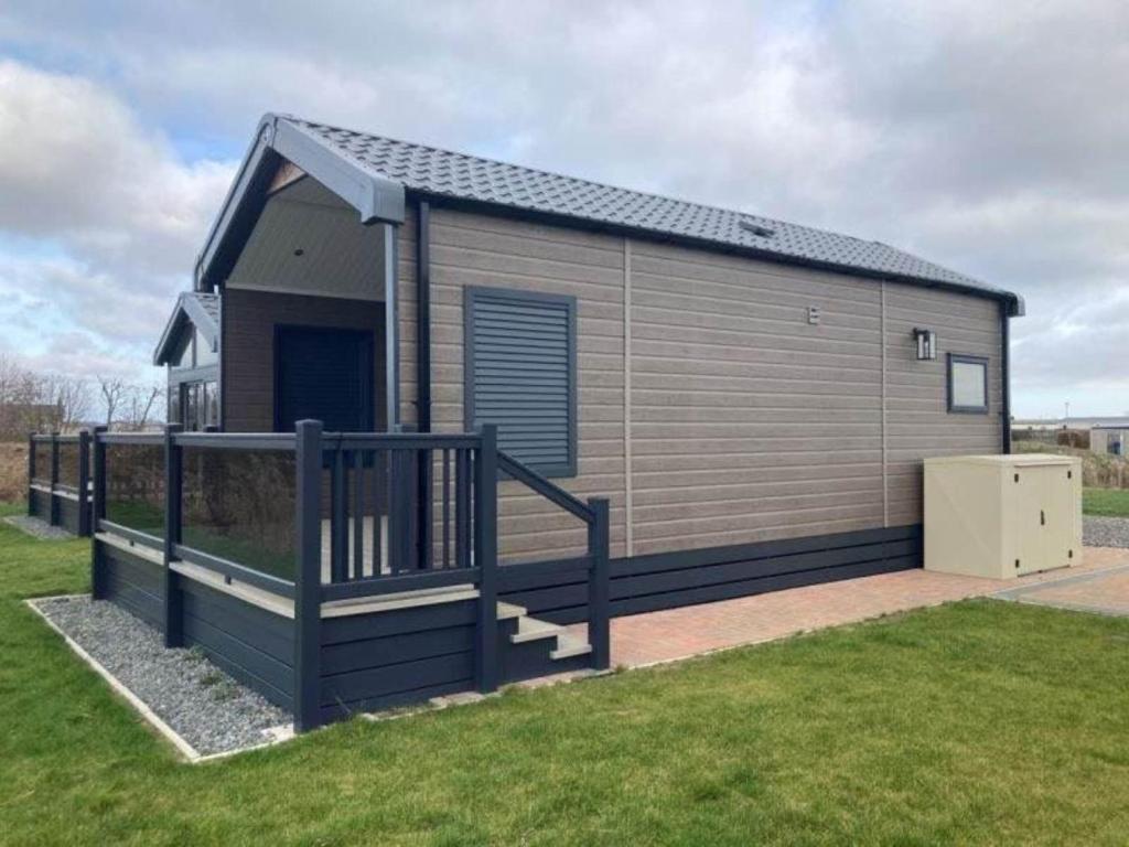 a small building with a staircase in a yard at Chapel Fields Holiday Park in Chapel Saint Leonards