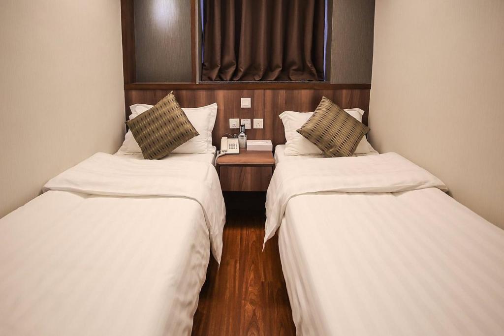 2 Betten in einem Zimmer mit weißer Bettwäsche in der Unterkunft Hygge House in Hongkong
