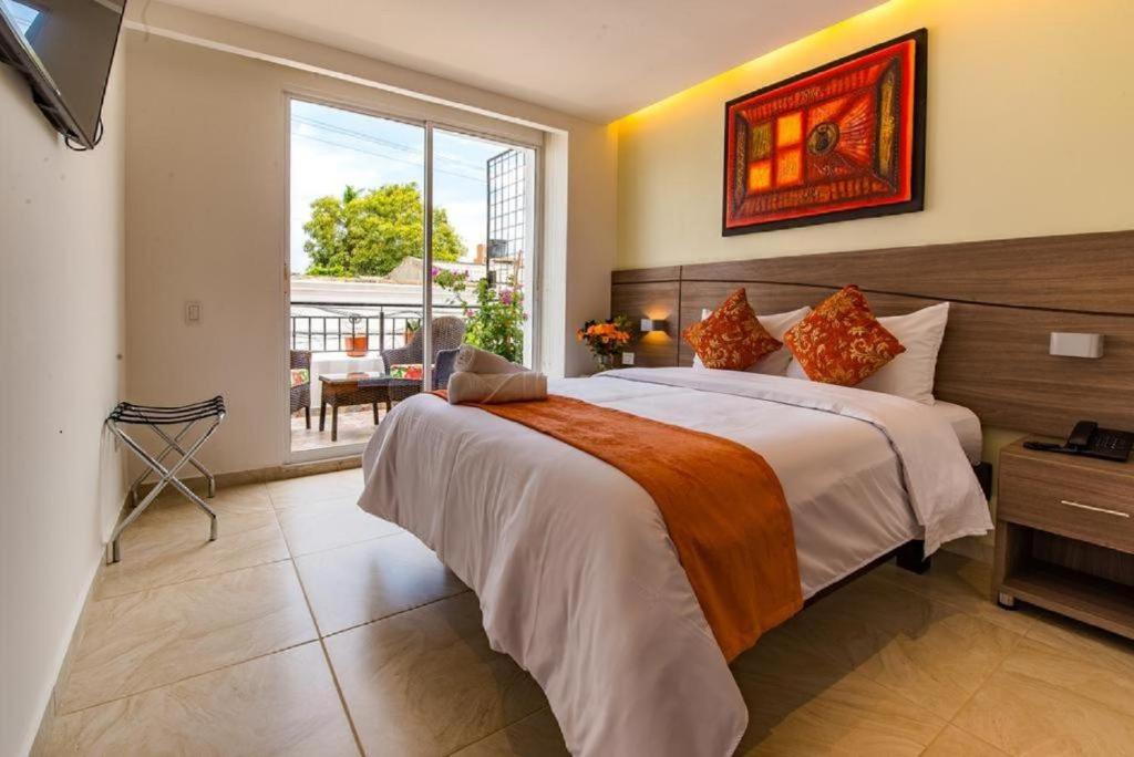 1 dormitorio con cama grande y ventana grande en Hotel Boutique Marbore, en Santa Marta