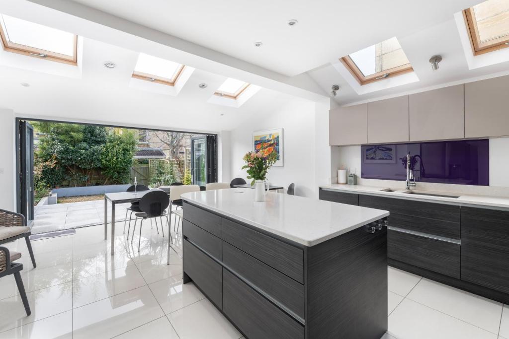 an open kitchen with a large island and skylights at Fabulous House - Only 10 minutes walk to Roman Baths in Bath